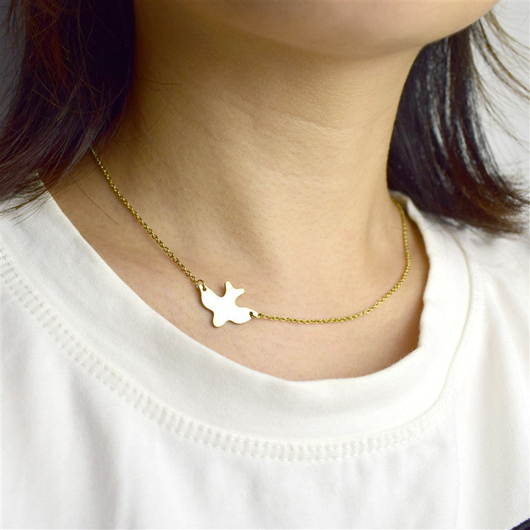 Little Dove Necklace, dainty gold dove pendant on a fine chain, worn at the neck
