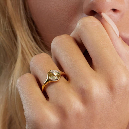 Mila Sunburst Ring, gold sunburst signet ring worn on a hand