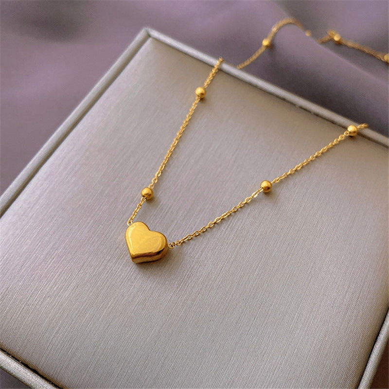 Tiny Heart Necklace, small gold heart pendant on a fine chain, close-up